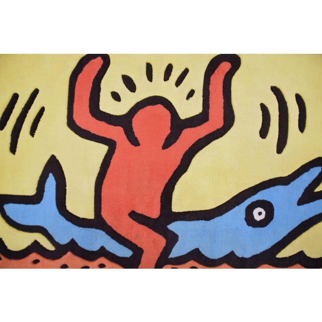 Vintage rug with 'Dolphin Ride' image designed by Keith Haring. This piece is designed in the style of the selected...