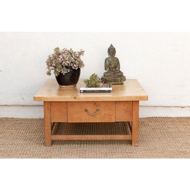 The thick, pale sycamore top on this table shows the kind of surface history that comes from a piece built for hard use...