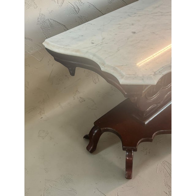 Beautiful vintage marble top console table with a unique carved lyre-style wood base. This piece has a classic Victorian-...