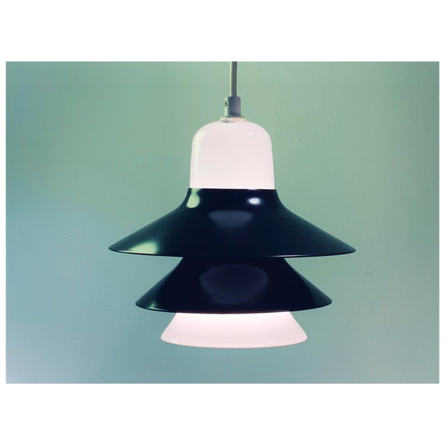 Elegant Scandinavian pendant lamp produced in Denmark during the 1970s. The lamp combines black lacquered metal shades...
