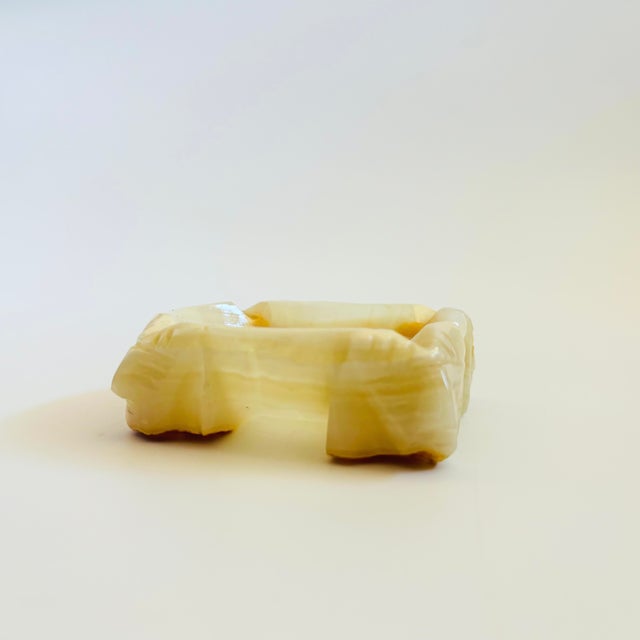 A vintage alabaster stone ashtray. Features an intricately carved Mayan design with heads on each of the 4 corners....