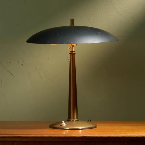 This Italian table lamp, crafted in the 1950s, features a minimalist design with a black adjustable shade and a sturdy...