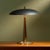 This Italian table lamp, crafted in the 1950s, features a minimalist design with a black adjustable shade and a sturdy...