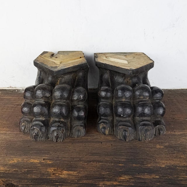 Pair of antique Italian hand-carved wooden corbels in the form of lion paws. A decorative architectural salvage piece with...
