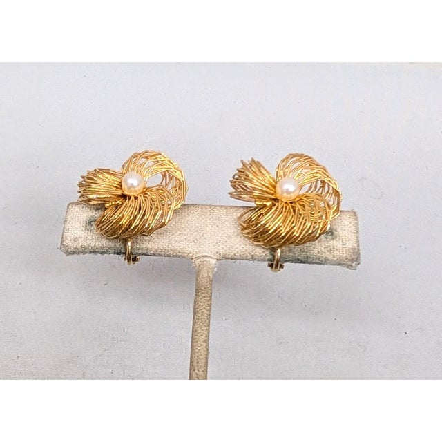 1980s goldtone wrapped wire 3 "petals" with faux-pearl center clip and screw back earrings. Marked "Les Bernard" on the...