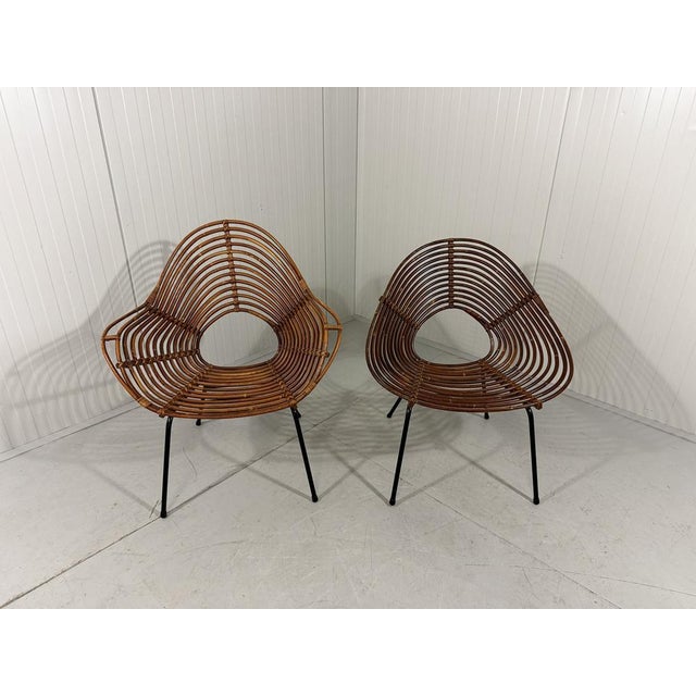 A pair beautiful rattan easy chairs by Rohé Noordwolde, Netherlands. Special shaped rattan seat on a black steel base....