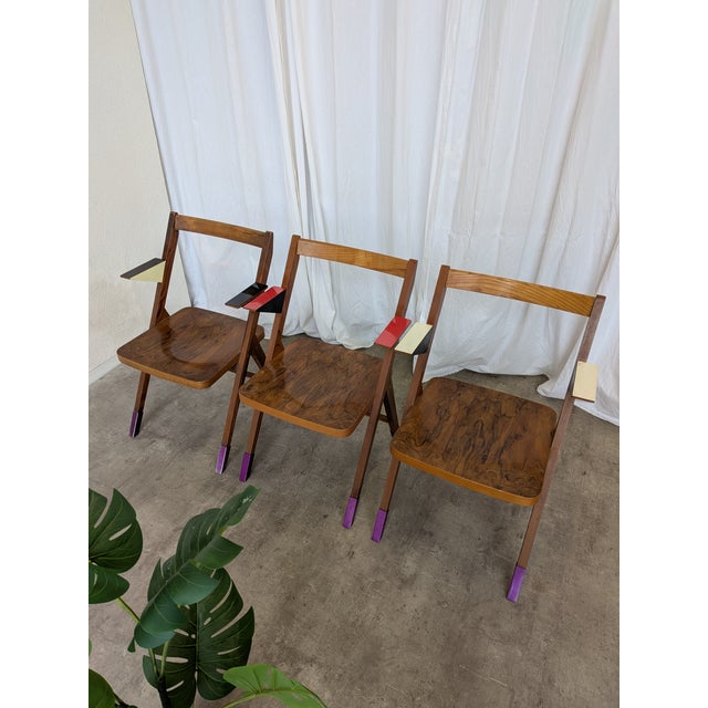 Set of 3 funky wooden armchairs made in former Yugoslavia in the 1970s. Chairs have metal purple leg protections and...