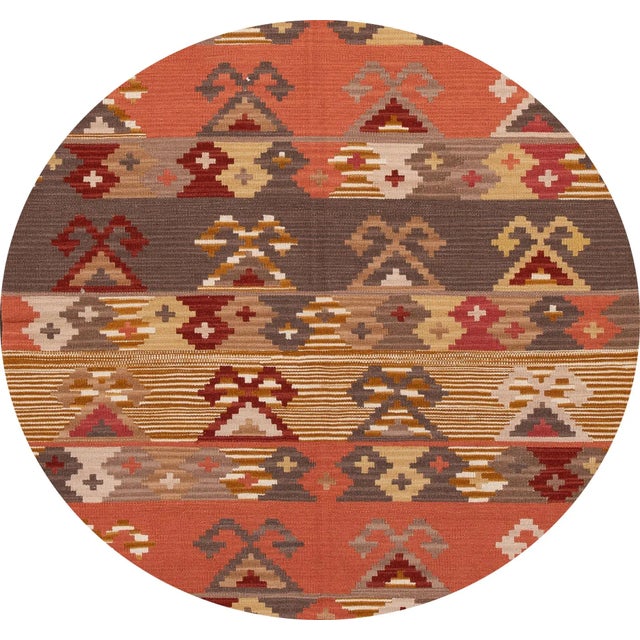 A beautiful hand-woven modern Kilim rug with a tan field and multi-color accents in an all-over geometric design. This rug...