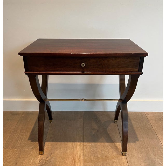 This elegant neoclassical-style side table or nightstand is made of... wood and brass. It is a French work in the style of...
