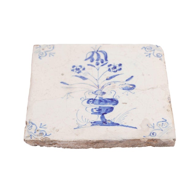 Delft faience tile in a cobalt underglaze blue with a Baroque arrangement of tulips in an urn. Tile has been cracked and...