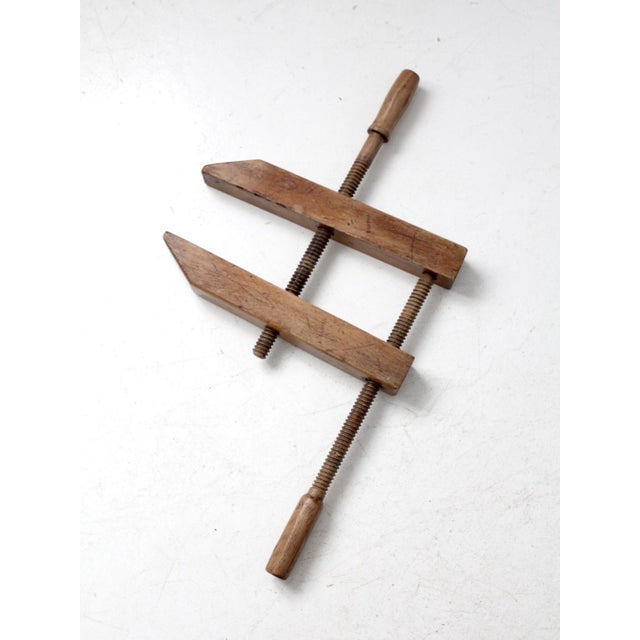 This is an antique wood clamp or vice. The woodworking clamp features is made entirely of wood, including the screw...