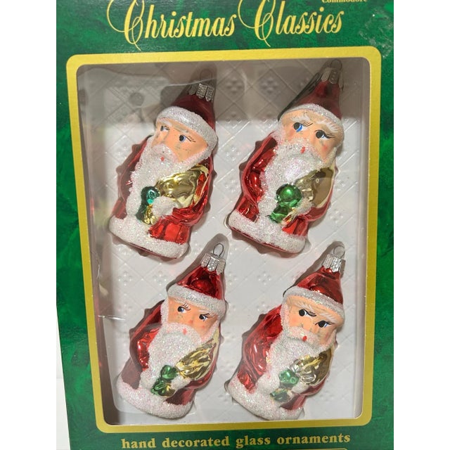 A charming vintage set of mercury glass Santa ornaments featuring hand-painted details and sparkling mica glitter accents....