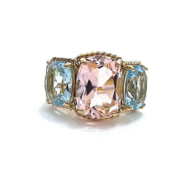 Christina Addison Elegant 18kt Yellow Gold Three Stone Ring with Light Pink Topaz center stone and Blue Topaz side stones...