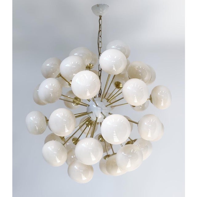 Italian sputnik chandelier with 40 cream Murano pebble glass shades mounted on brass frame in unlacquered natural brass...