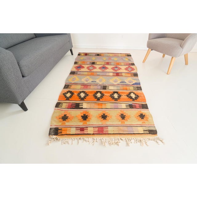 This is a vintage Turkish Oushak rug from the Mid 20th Century. The piece was hand-knotted.