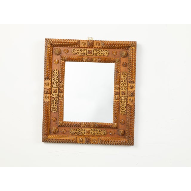 A French Tramp Art mirror from the early 20th century, with raised rosettes and ornate brass accents. Created in France at...