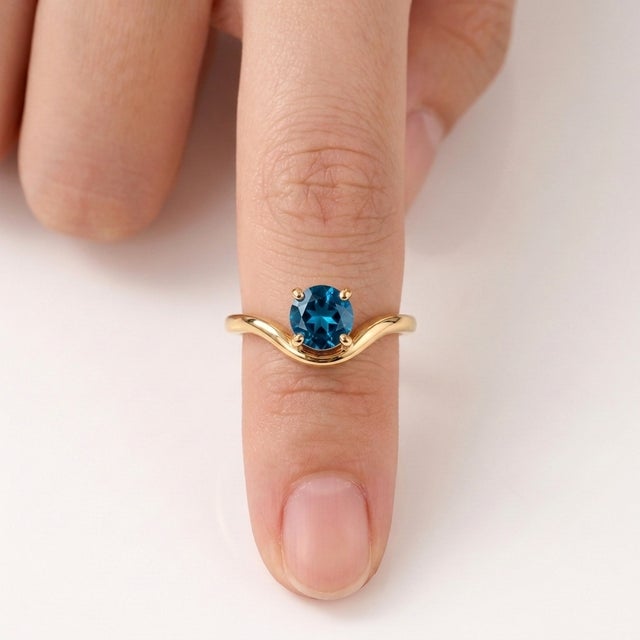 Add a refreshing splash of vibrant blue to your jewelry rotation with this serene curved solitaire ring. Designed with a...