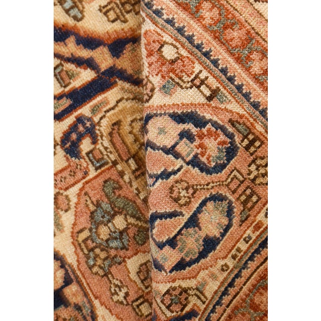 This antique Persian rug is a paragon of the northwestern Malayer style. Its main field carries a masculine paisley design...