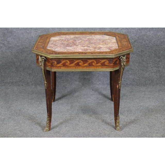 This exquisite antique French side table showcases the timeless elegance of early 20th -century craftsmanship, featuring a...