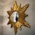 This striking mid-century giltwood starburst mirror features dynamically layered, hand-carved wooden rays finished in an...