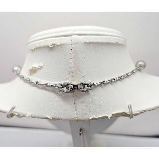 1960s rhodium plated pendant with textured top and tassel bottom on a chain with spherical textured beads at intervals...