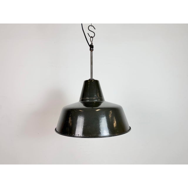 Industrial black enamel pendant light made in Germany during the 1950s. White enamel inside the shade. Iron top. The...