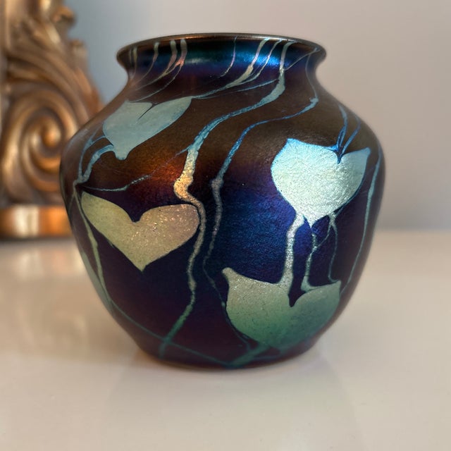 A beautiful piece of iridescent art glass in the style of Tiffany, Durand, and Lundberg. This petite vase features a...