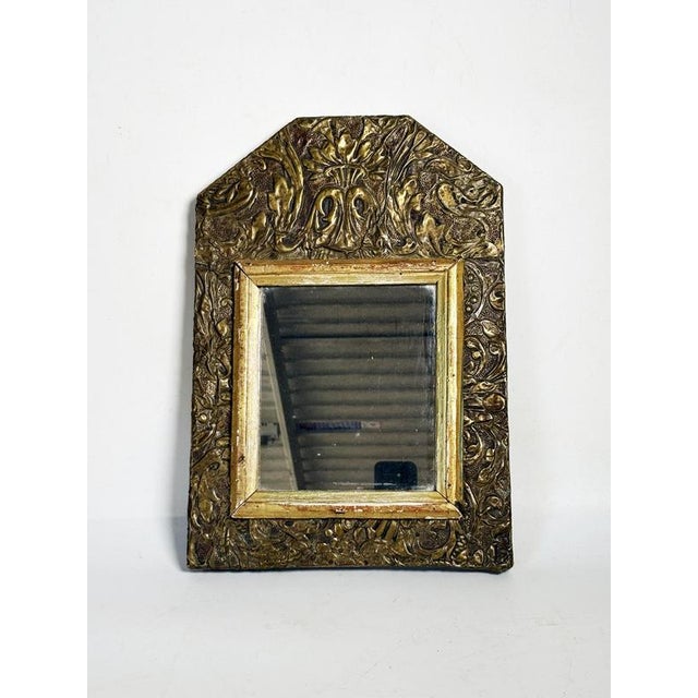 Small decorative mirror in gilt metal and wood, made in France in the 1970s. Its frame, richly decorated with raised...