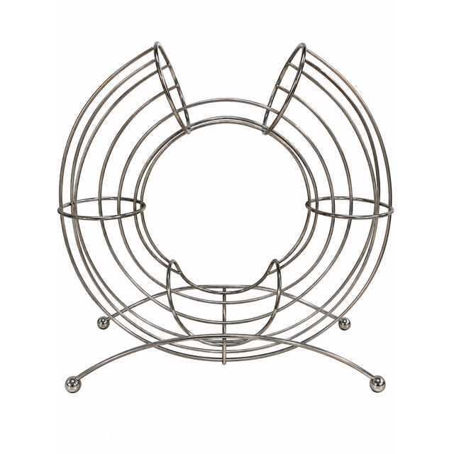 A striking pair of sculptural chrome wire orange holders, combining practical storage with bold, playful mid-century-...