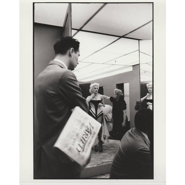 This captivating black-and-white photograph offers a rare glimpse into the backstage life of Marilyn Monroe. Taken in the...