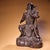 This is a cast bronze statue of a seated warrior deity, likely representing Guandi (the deified Guan Yu). The figure is...