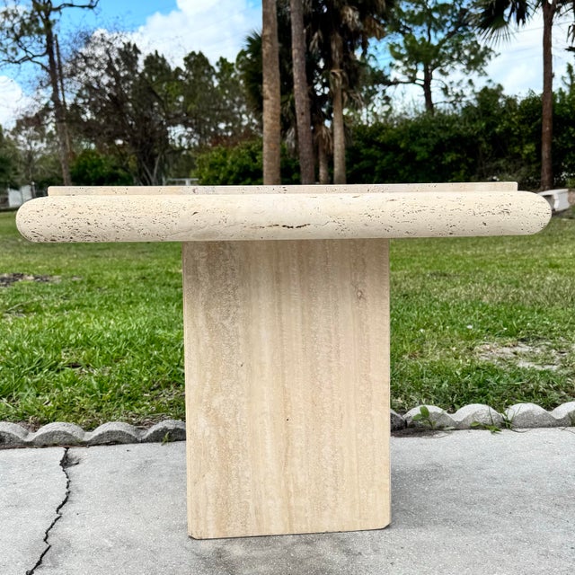 A striking vintage Italian side table crafted from beautifully veined natural travertine. The square top sits within a...