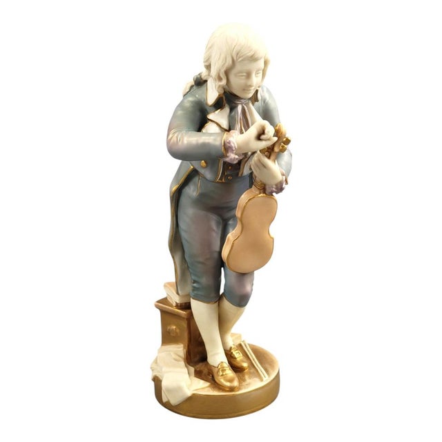 A finely modelled Royal Worcester bone china figure of “The Young Mozart”, model 1487. The young violinist stands tuning...