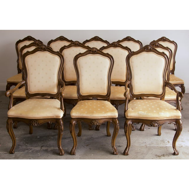This is a set of twelve Louis XV-style dining chairs by Karges: two armchairs and ten side chairs. Each chair has a hand-...