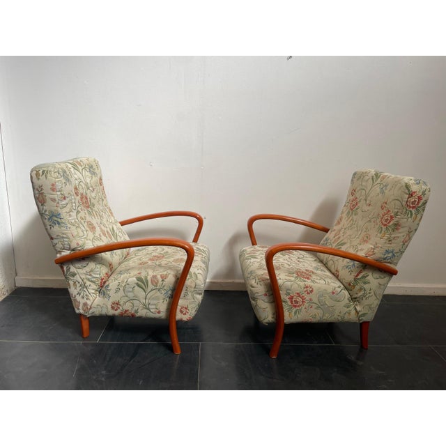 Elegant pair of 1960s Italian armchairs in orange-stained beech, with armrests featuring distinctive dowel joints....