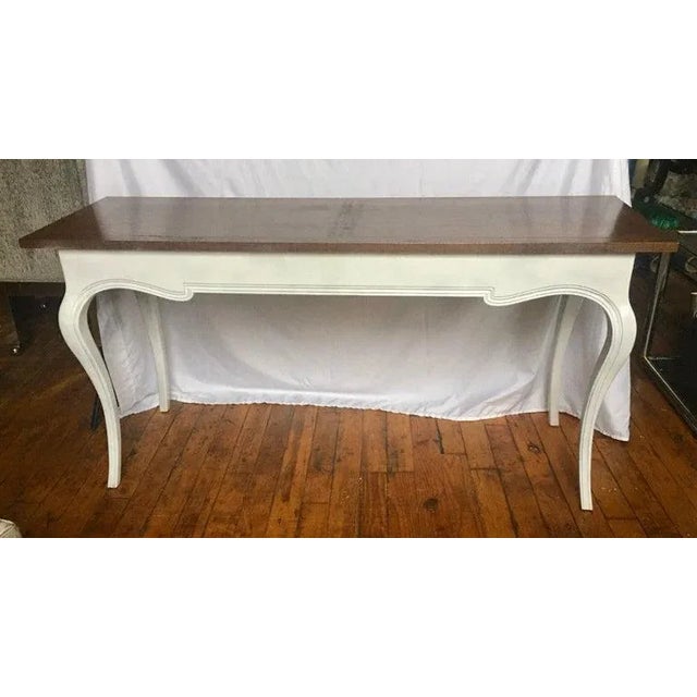 Midcentury French Provincial style console sofa table by John Stuart. Base features a white painted finish with curved...