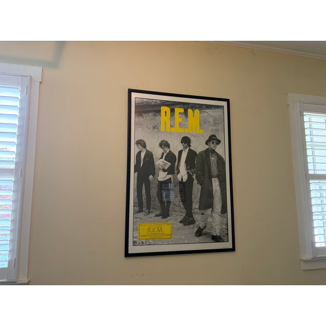 This item is a vintage framed poster featuring the American rock band R.E.M. Subject: The poster displays a black and...