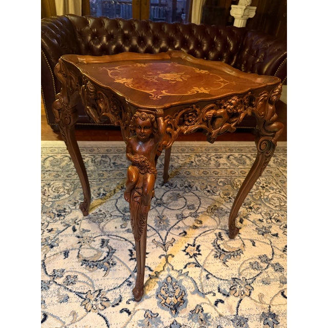 Antique Hand-Carved Rococo-Style Side Table with Cherub Figures & Marquetry Top An exceptional antique carved side table,...