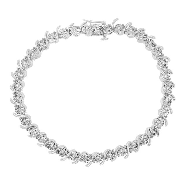 Elegant and timeless, this gorgeous 92.5% sterling silver tennis bracelet features 0.1 carat total weight of natural round...