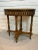 An elegant vintage oval side table dating to circa 1940s, featuring beautifully detailed marquetry accented by decorative...