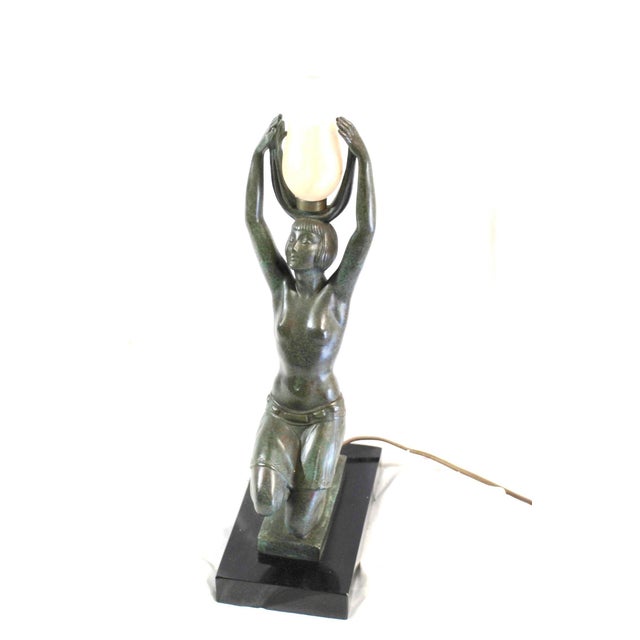 Deco girl lamp cast in Bronze with a green patina. After one of the famous Art Deco Artist . Mounted on an absolute black...