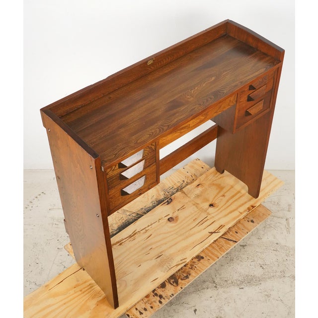 Mid Century Modern medium tone oak office desk with clean lines and geometric wood drawer pulls. It features six drawers...