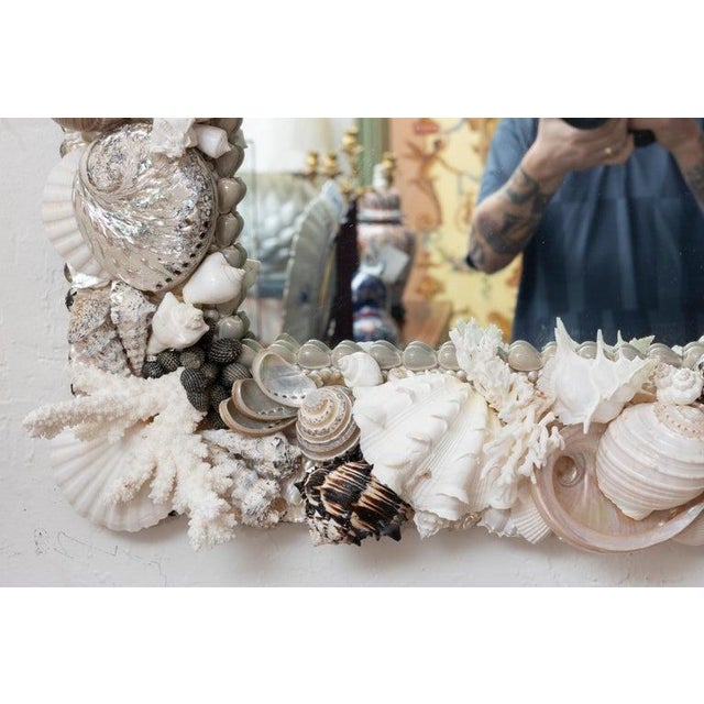 This is a striking coastal-inspired mirror, the rectangular frame lavishly encrusted with an organic arrangement of...