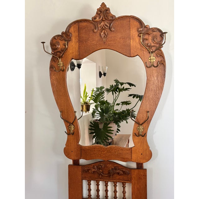 Beautiful American quarter-sawn oak hall tree with a seat. The large mirror was cut to shape and bordered by the original...
