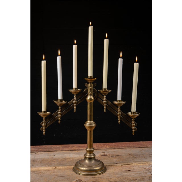 Solid brass seven-light adjustable candelabrum featuring a central standard with pivoting candle arms that expand into an...