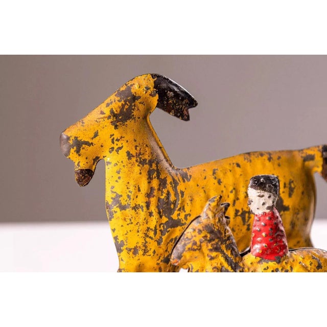 An antique tin toy depicting a goat and a horse on a wheeled platform produced by James Fallows & Sons. Made in...