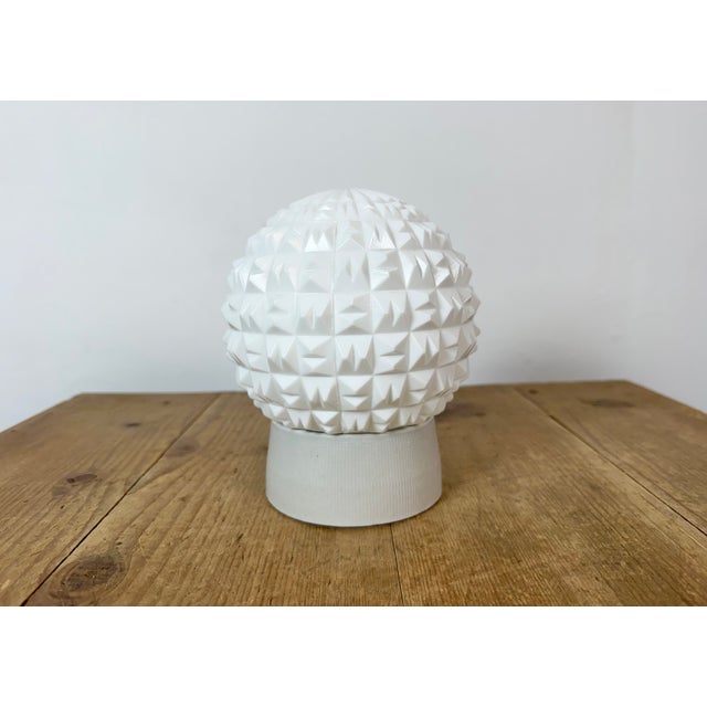Vintage industrial ceiling or wall light made in former Czechoslivakia during the 1970s. It features a white porcelain...