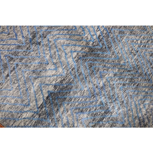 An early 21st Century Moroccan rug in gray and blue. The wool is lustrous and soft and cozy on the feet Measures: 7'6'' x...
