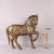Wooden horse covered in embossed and chiseled brass and copper sheet metal with applied bells, reins and chain. This piece...