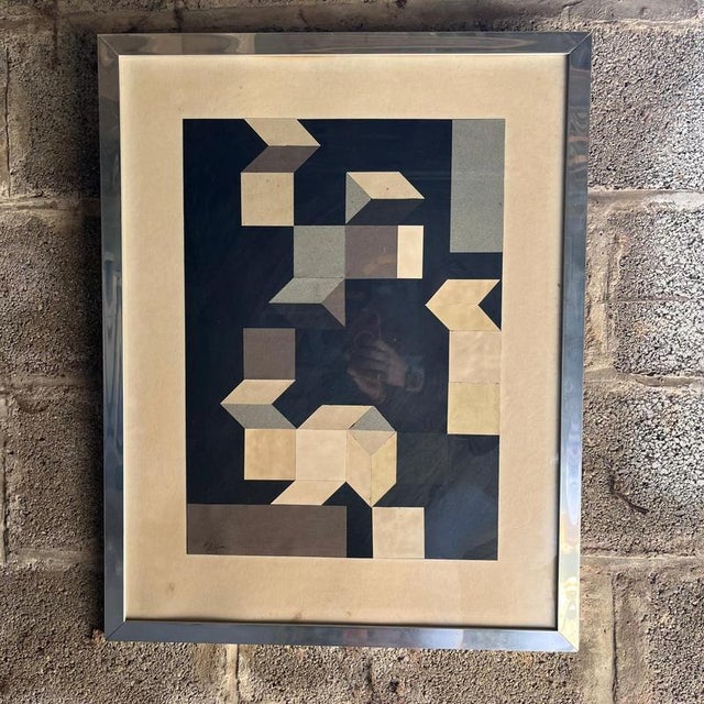 Framed Abstract geometric print depicting interlocking cube like forms in tones of black grey and cream in a modernistic...